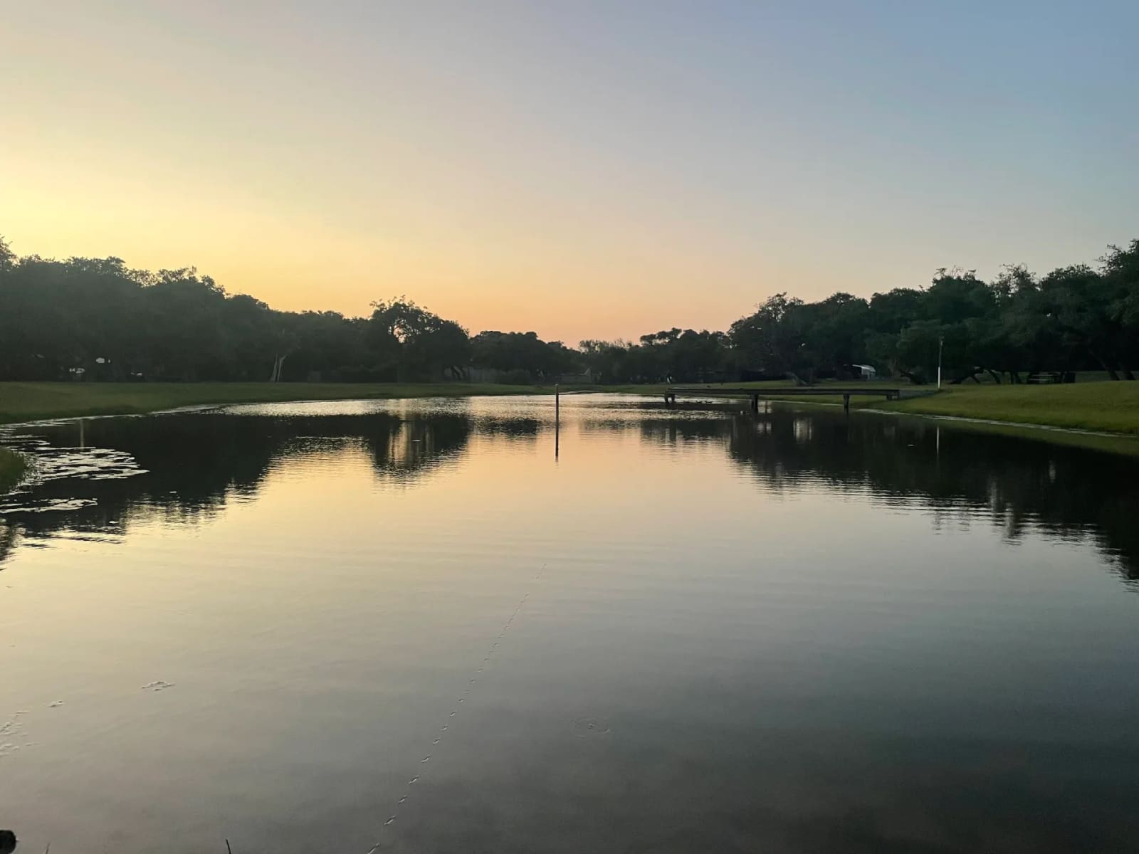 The 2-acre fishing pond at sunset with the dock, New Season RV Resort, Aransas Pass TX